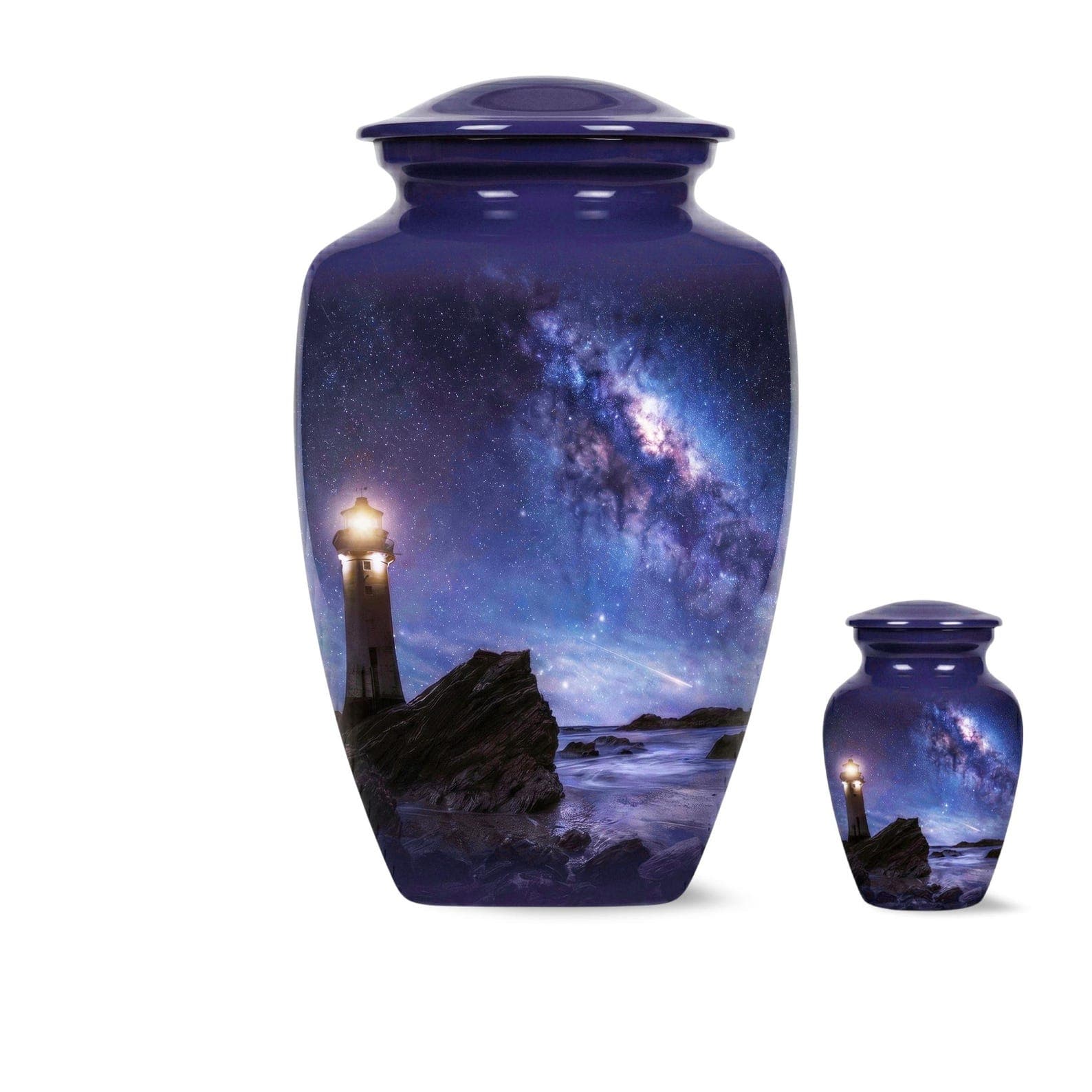 Two dark blue cremation urns of different sizes, each featuring a cylindrical body and a matching lid. The surface displays a night scene with a glowing lighthouse on a rocky shore under a vibrant purple and blue starry 