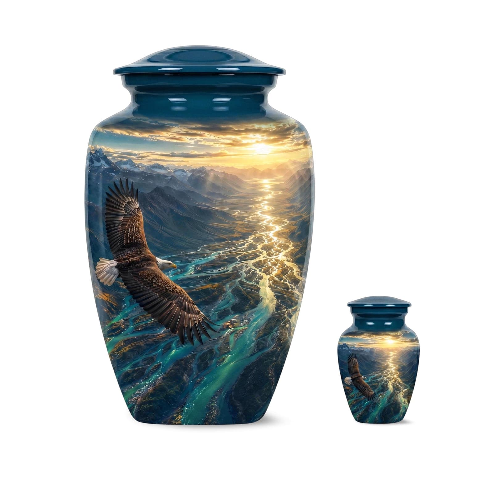 A large and a small blue cremation urn, each featuring a matching wrap-around graphic of a bald eagle in flight over a winding river valley at sunset, with mountains in the background and a solid blue lid on each vessel.